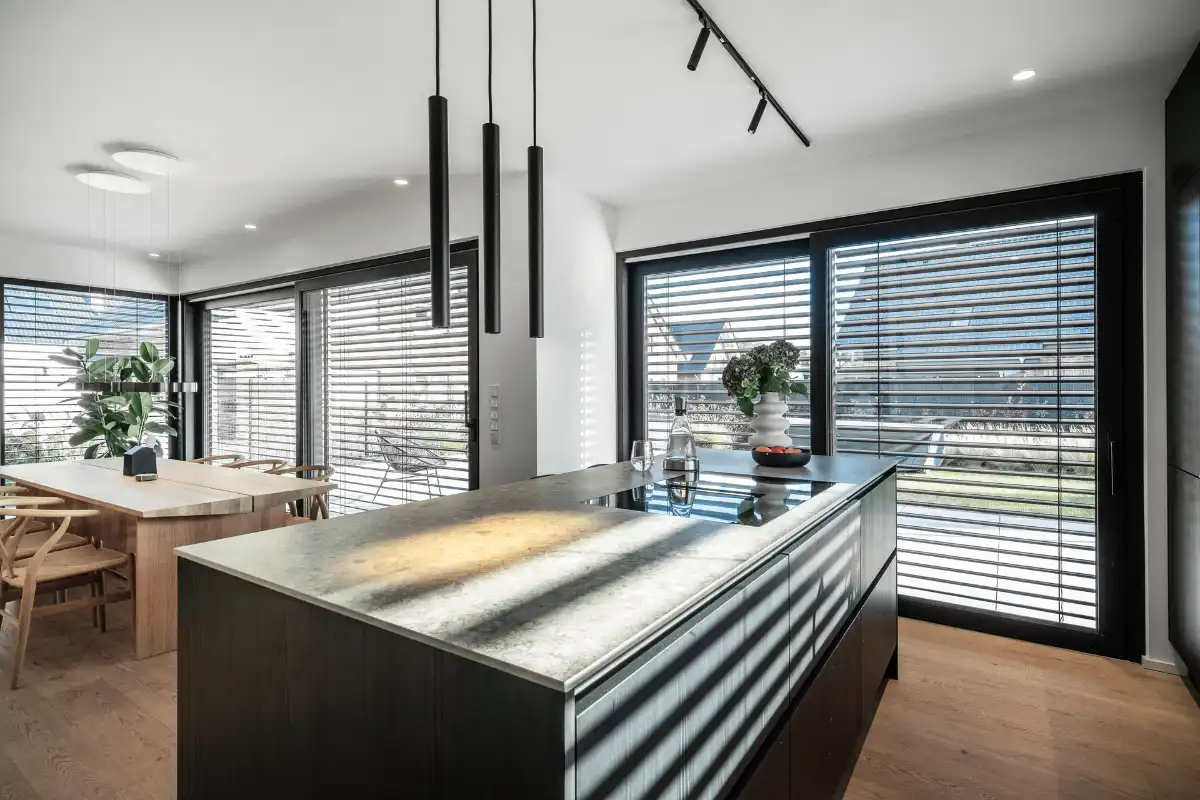 Moderne Küche mit großen Fenstern und Außenjalousien
