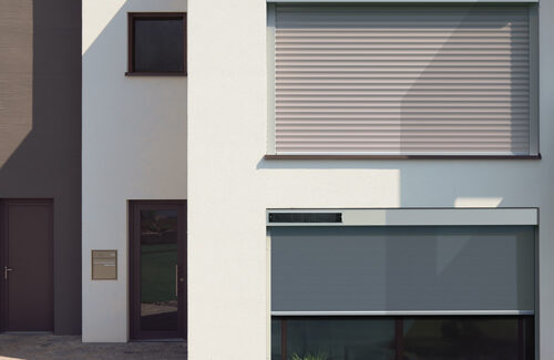 Rollladen mit Solarmodulen an der weißen Fassade eines Hauses
