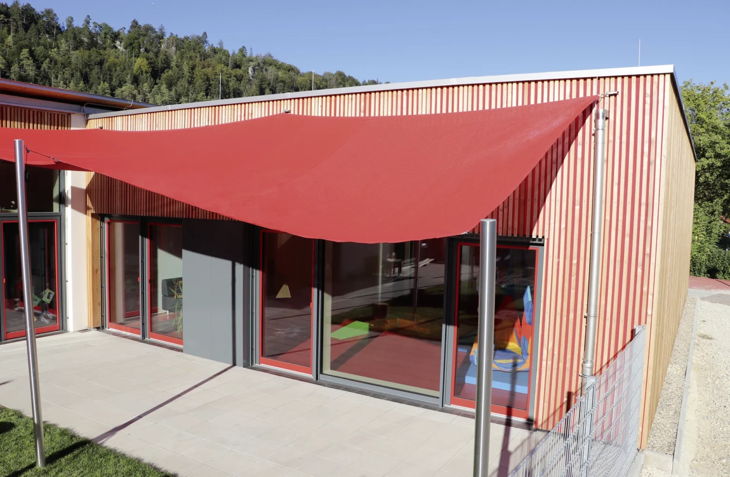 Modernes Gebäude mit rotem Sonnensegel