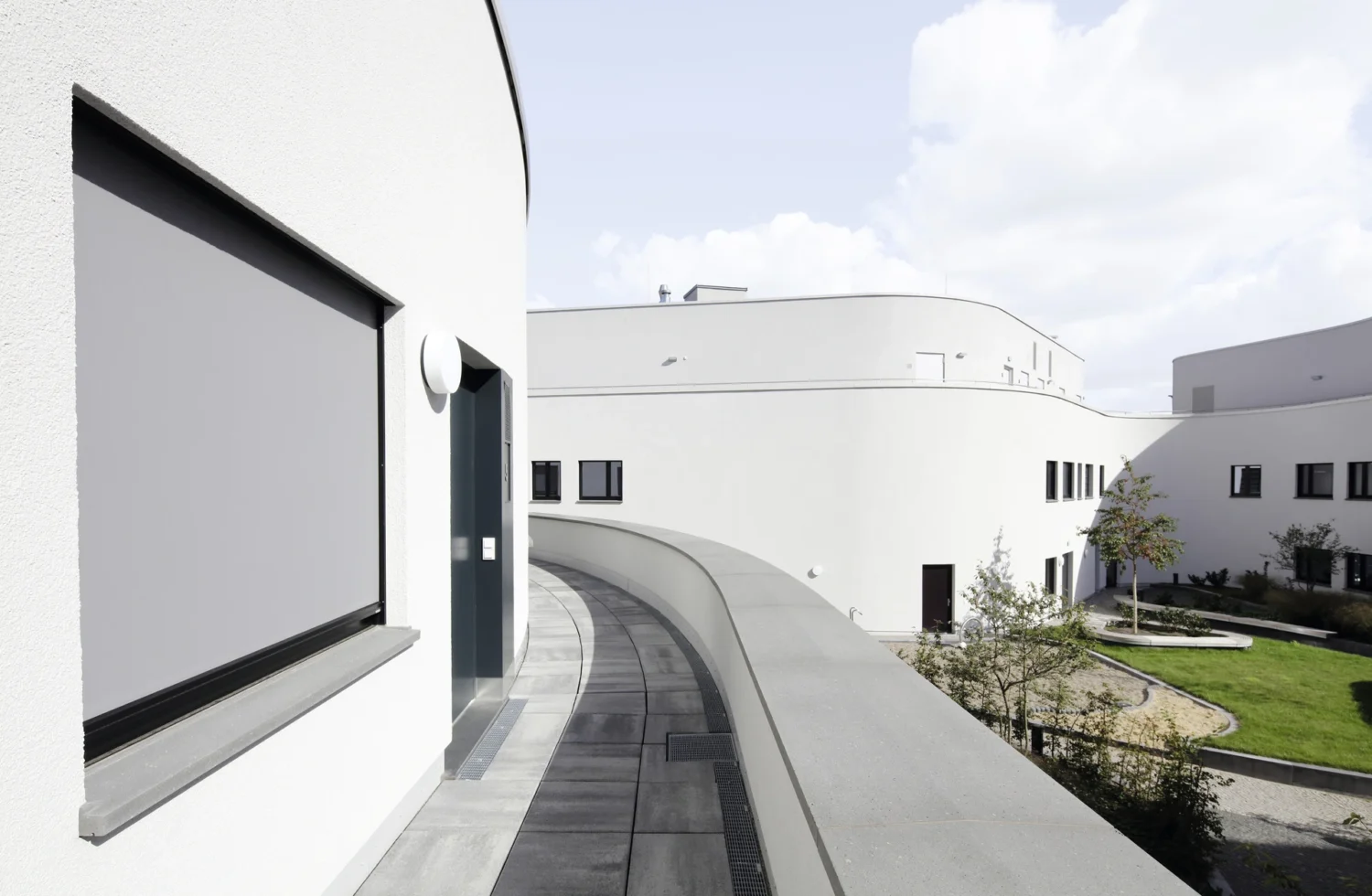 Moderner Gebäudekomplex mit geschwungener Architektur und Innenhof